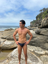 Load image into Gallery viewer, Salty Johnson sustainable mens swim briefs in black, perfect for beach and water activities