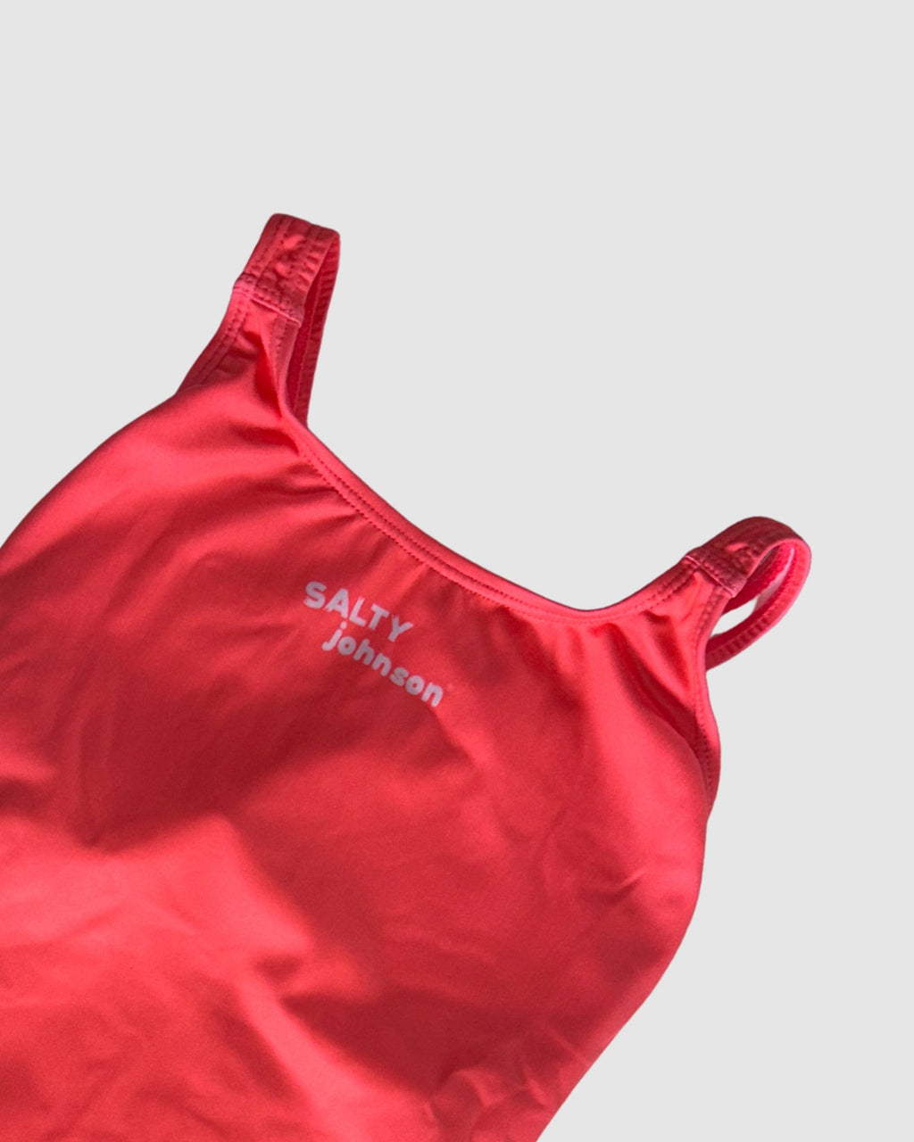 Neckline and strap detail of Classics Watermelon women's thick strap one-piece swimsuit, solid watermelon red.