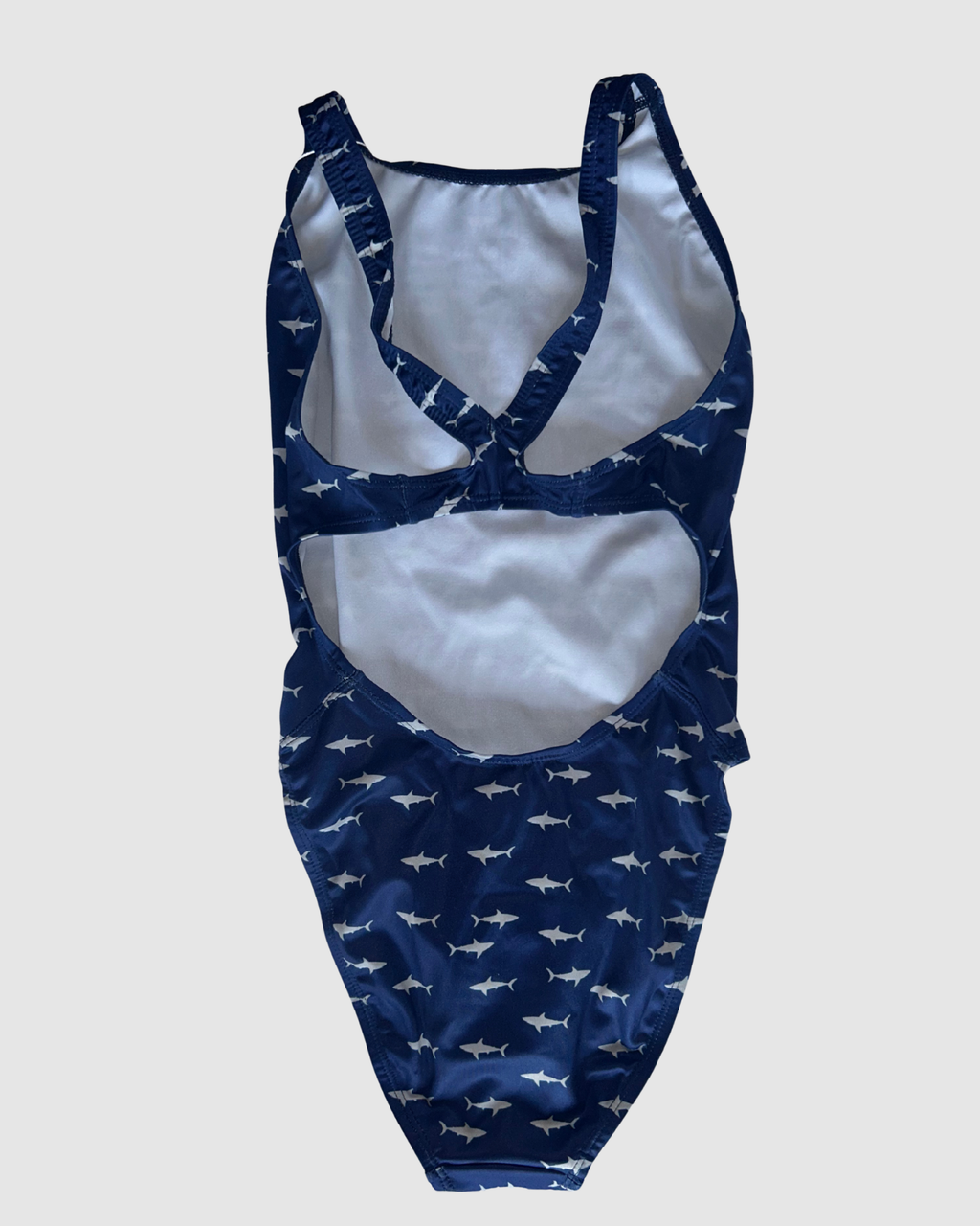 Open cross-back view of White Pointer women's thick strap one-piece swimsuit, grey sharks on navy.