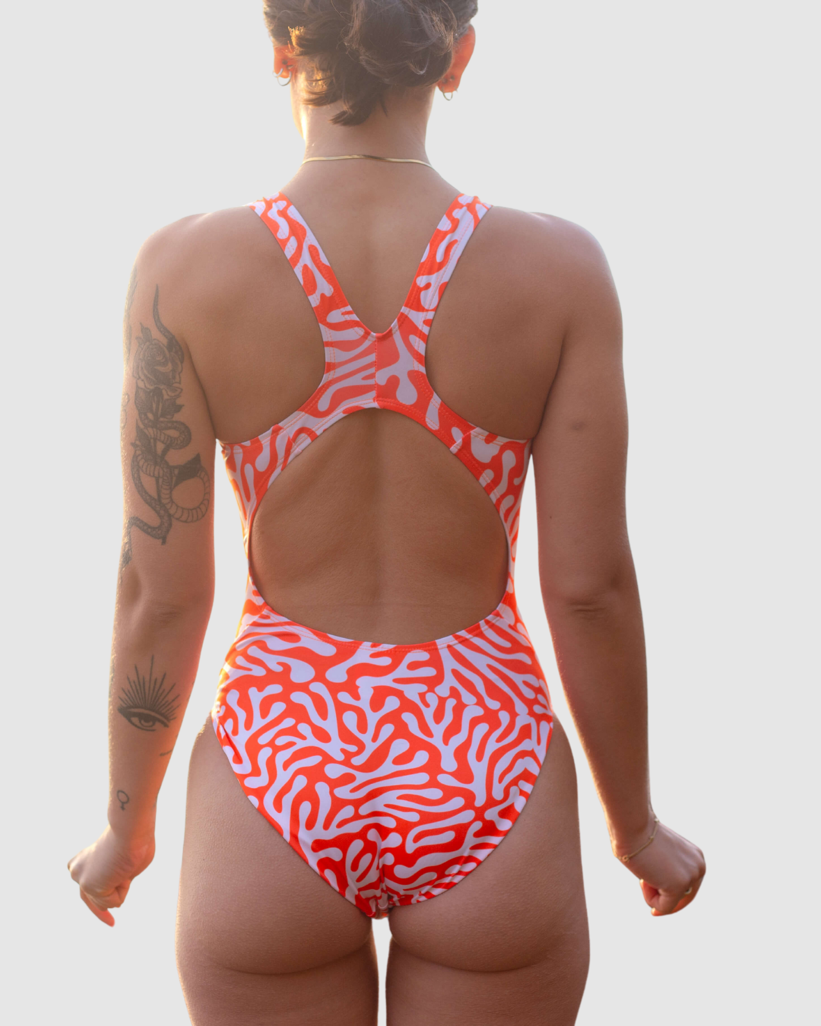 Back view of a vibrant Salty Johnson AU sustainable womens one piece swimsuit featuring a coral pattern